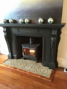 a wood burning stove sitting inside of a living room next to a wooden floor and wall