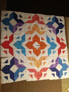 a colorful quilt is laying on the floor