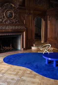 a blue coffee table sitting in front of a fire place on top of a wooden floor