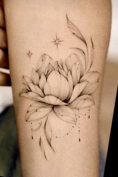 a black and white photo of a flower on the right thigh, with stars in the background