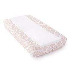 a baby crib mattress with white and pink geometric print on the bottom, in front of a white background