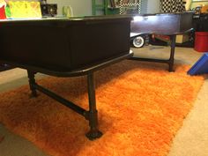 a black table sitting on top of an orange rug