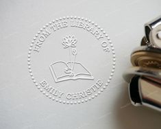 a stamp with the words from the library on it and a book in front of it