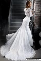 a woman in a wedding dress is standing on the stairs