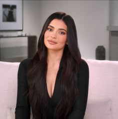 a woman sitting on top of a white couch