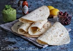 three tortillas sitting on top of a towel next to a bowl of beans