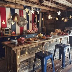 an american flag themed kitchen with stars and stripes on the wall, along with blue stools