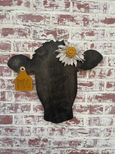 a cow with a flower on it's head is mounted to a brick wall