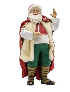 a figurine of santa clause pointing to the right with his left hand up