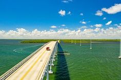 an aerial view of a bridge spanning the ocean