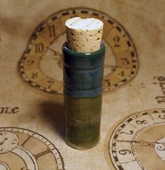 a small bottle sitting on top of a table next to a clock face wallpaper