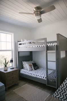 a bedroom with two bunk beds and a ceiling fan