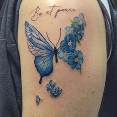 a blue butterfly with flowers on it's back shoulder that says be at peace