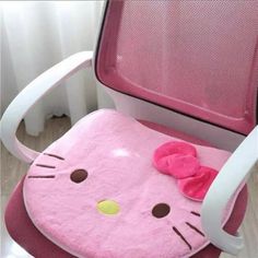 a pink hello kitty chair with a bow on it's seat pad and back