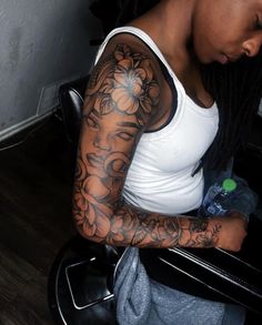 a woman with tattoos on her arm sitting in a chair