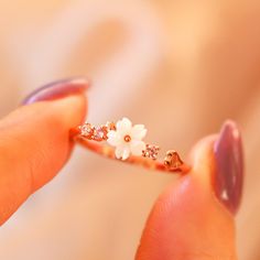 Description: Feel your style flower with our dainty White Flower Ring! Crafted with mother of pearl flower and dainty pink gems, it's sure to bring a twinkle to any outfit. Blooming gorgeous! Ring Details: Material: 18K Rose Gold Vermeil / 18K Gold Vermeil / Sterling silver Anti-allergy and nickel-free. Size: 4-8 Adjustable. Designed in LA In order to extend the life of your jewelry, please remove jewelry before swimming, exercising & bathing. White Flower Ring, Gorgeous Ring, Pink Gem, Pearl Flower, Flower Ring, White Ring, White Flower, 18k Rose Gold, Rose Gold Ring