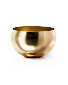 a gold bowl sitting on top of a white table