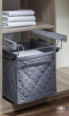 an organized closet with folded towels and storage bins