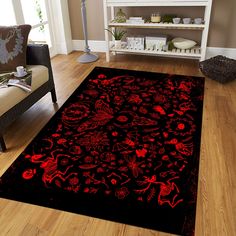 a red and black area rug with an intricate design on the floor in a living room