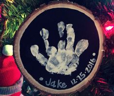 a handprint ornament hanging on a christmas tree