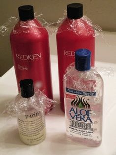 two bottles of aloe vera and redken on a white counter top with plastic wrap around them