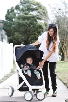 a woman pushing a stroller with a baby in it