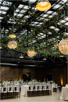 the tables are set up for an event with chandeliers hanging from the ceiling