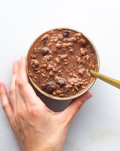 a person holding a bowl of chocolate pudding