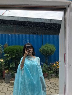 a woman taking a selfie in front of a mirror with an umbrella over her head