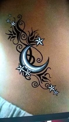 the back of a woman's stomach with a crescent and stars tattoo on it