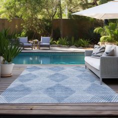 an outdoor area with a pool, patio furniture and umbrellas in the background on a wooden deck