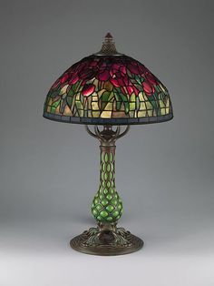 a lamp that is sitting on top of a table with a glass shade over it