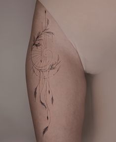 a woman's thigh with an arrow tattoo on the side and feathers drawn on it