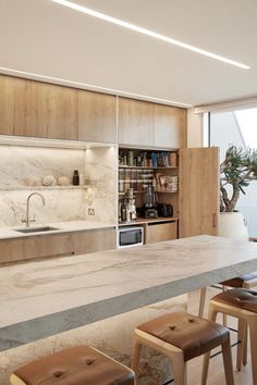 a kitchen with marble counter tops and stools