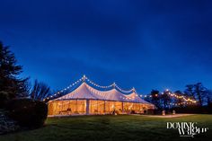 a large tent is lit up at night with fairy lights on the roof and windows