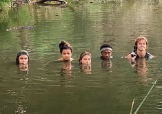 several people are swimming in the water with one person holding a camera up to their face