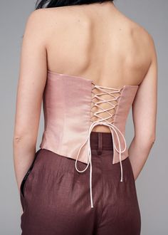 Elevate your style with the IRA LYSA Pink Metallic Corset. Stand out in the crowd while not compromising on comfort. The pink is delicate but the corset shape keeps this piece chic and high-fashion. * Made with corset boning* Air loops and long spaghetti strap on the back* Wave bottom finish Material: 100% European linen Handmade. Always. Luxury Bustier Corset With Bust Darts, Spring Satin Fitted Corset, Pink Party Corset With Corset Back, Spring Party Corset With Boning, Chic Corset With Sweetheart Neckline And Straps, Elegant Spring Corset Dress With Boning, Fitted Corset Dress With Boning For Spring, Pink Corset With Sweetheart Neckline And Built-in Bra, Fitted Overbust Spring Corset