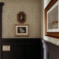 an ornate wallpapered room with framed pictures on the wall