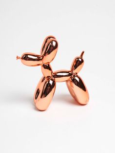 the balloon dog brooch is made out of shiny copper foil and has four legs