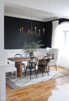 the instagram page shows an image of a dining room with black walls and white furniture