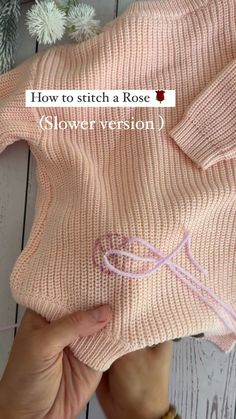 someone is stitching the stitches on a pink knitted sweater with text overlay that reads how to stitch a rose flower version