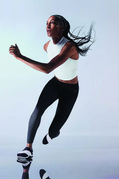 a woman is jumping in the air with her hair flying through the air while wearing roller blades