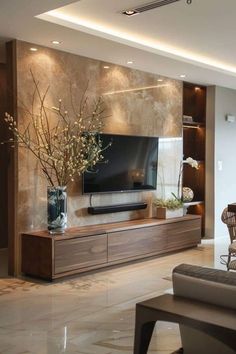 a living room filled with furniture and a flat screen tv on top of a wooden entertainment center