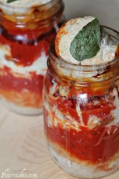 two jars filled with food sitting on top of a table