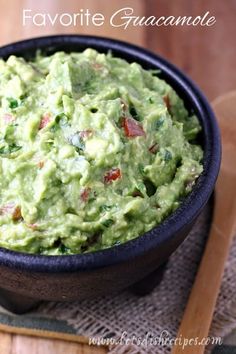 a black bowl filled with guacamole on top of a table