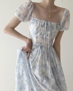 Inspired by Chinese porcelain, this dress features fruit trees, birds and bees sketched in dark blue and set on a delicate sheer white fabric. Crafted with a square neckline, short puff sleeves, tie up chest, cinched waist with smocked back and long flowy skirt. Finished with a concealed back zipper for easy wearing. Lined. S: 33" chest, 26" waist, 45" lengthM: 34.5" chest, 27.5" waist, 45" lengthL: 36" chest, 29" waist, 45" lengthXL: 37.5" chest, 30.5" waist, 45" length Shabby Chic Dress, Cottagecore Fashion, Dress Cottagecore, Cottagecore Dress, Floral Print Midi Dress, Midi Short Sleeve Dress, Printed Midi Dress, Flowy Dress, Summer Dresses For Women