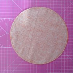 a circular piece of fabric sitting on top of a cutting mat