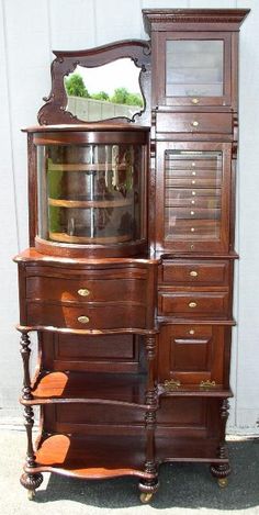 an old wooden dresser with a mirror on it's top and drawers below the drawer