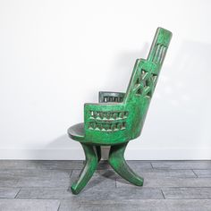 a green chair sitting on top of a tiled floor