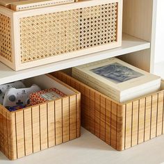 two wooden boxes with books in them on top of a white shelf next to a bookcase